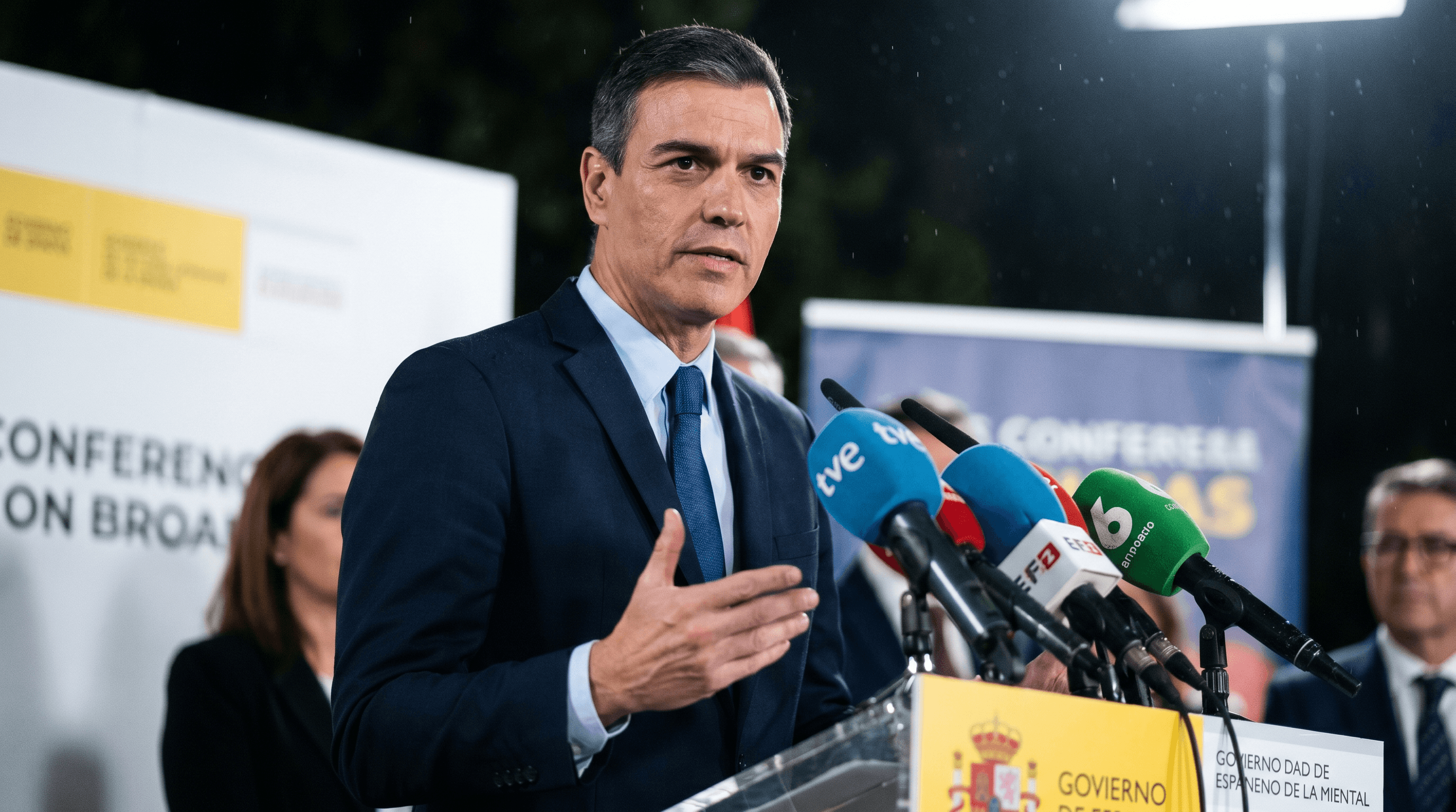 Pedro Sánchez en un atril de prensa con el logo del Gobierno de España, con expresión seria y reflexiva, defendiendo la acción de Lamine Yamal.